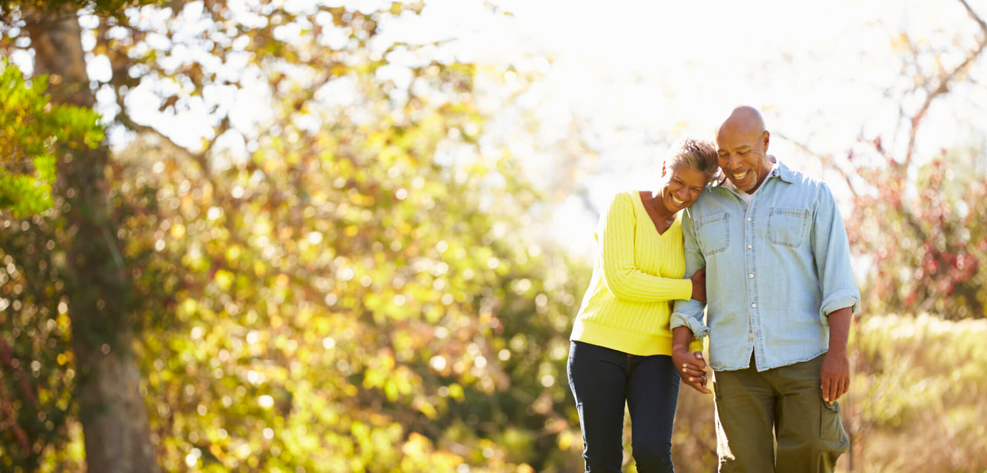 Senior couple walking through a woods during fall
