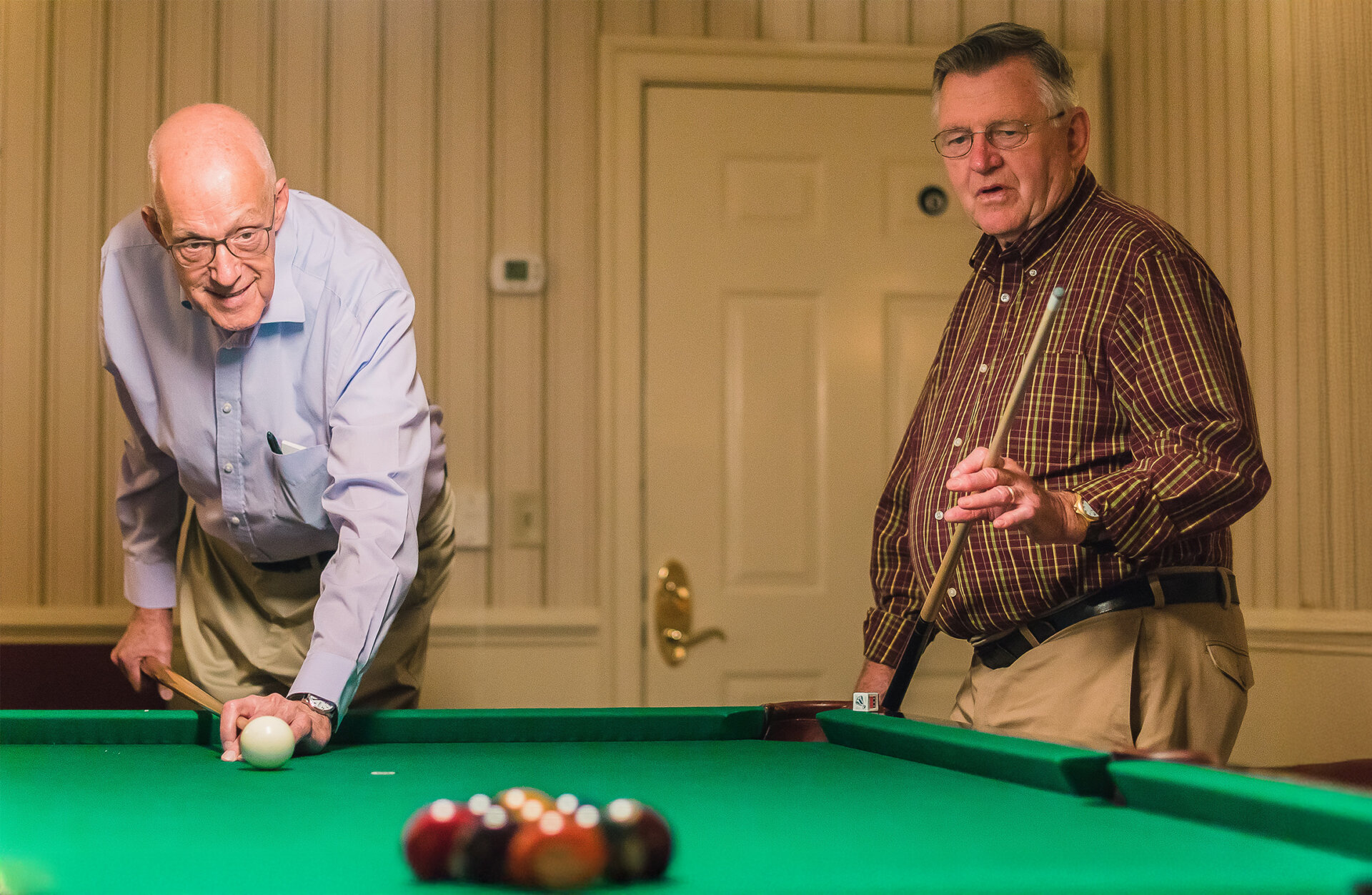 summit-friends-playing-pool Senior friends play pool at The Summit