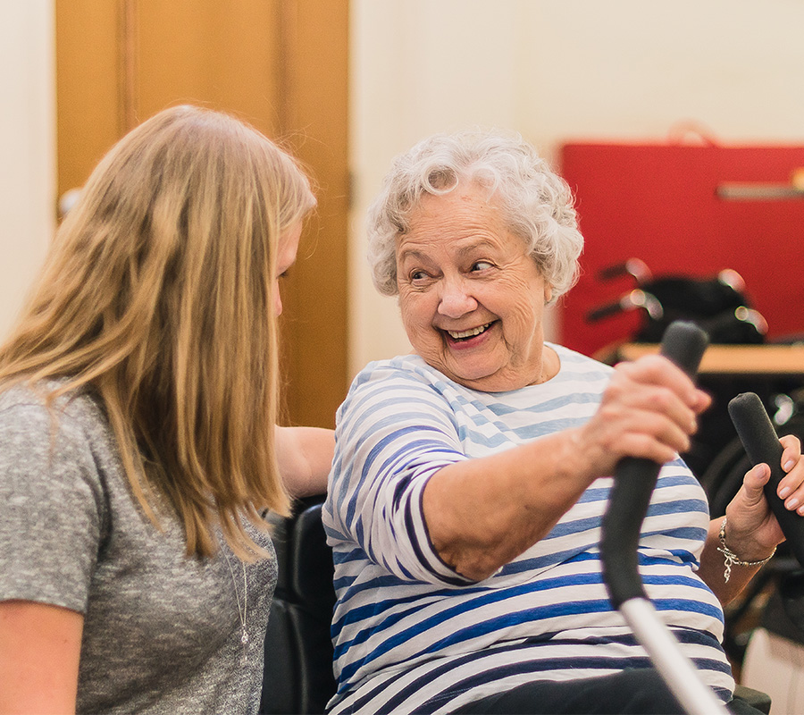 Senior woman smiles at physical therapist at rehab
