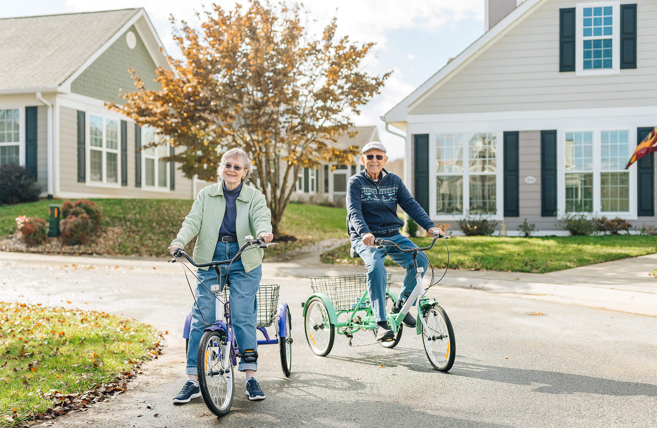 Senior couple riding tricycles in neighborhood