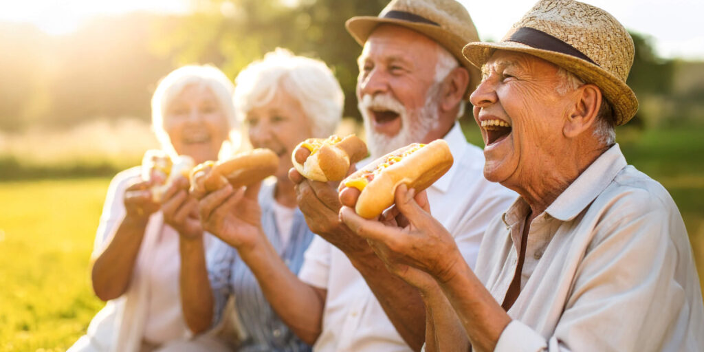 Seniors enjoying hot dogs outdoors