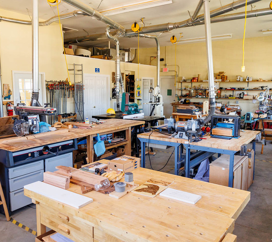 Woodworking shop with various tools, workbenches, and equipment for community projects.