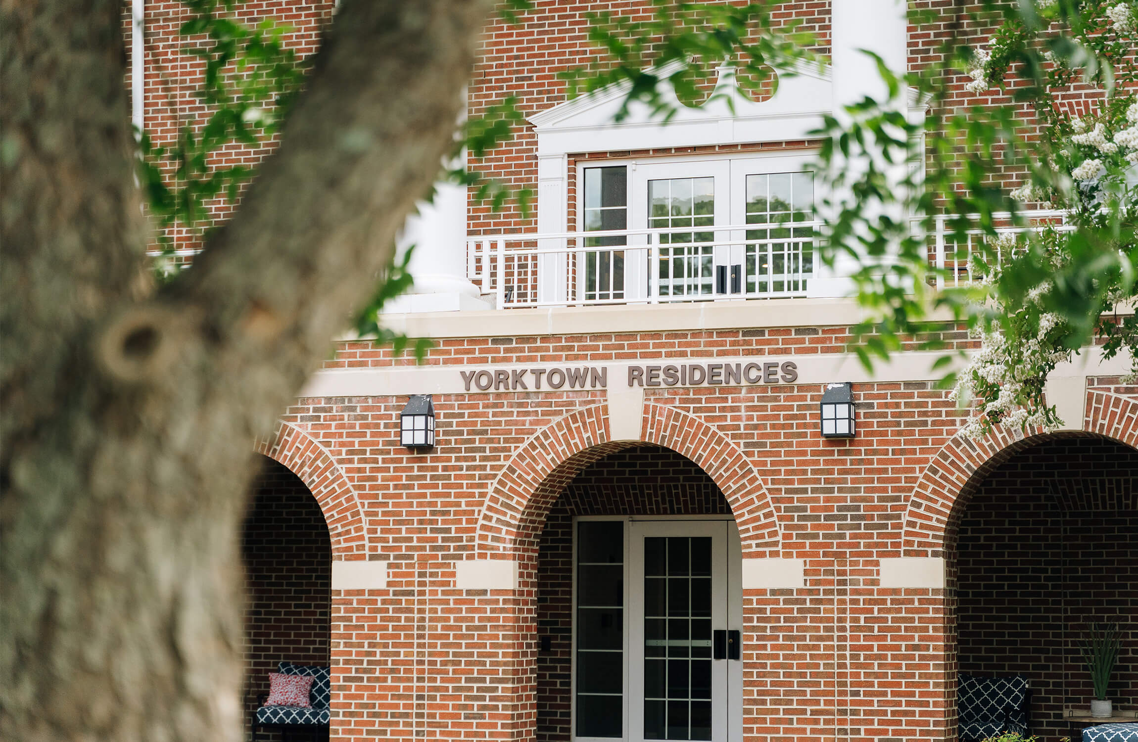 Brick facade of Yorktown Residences with arched entryways and white railings.