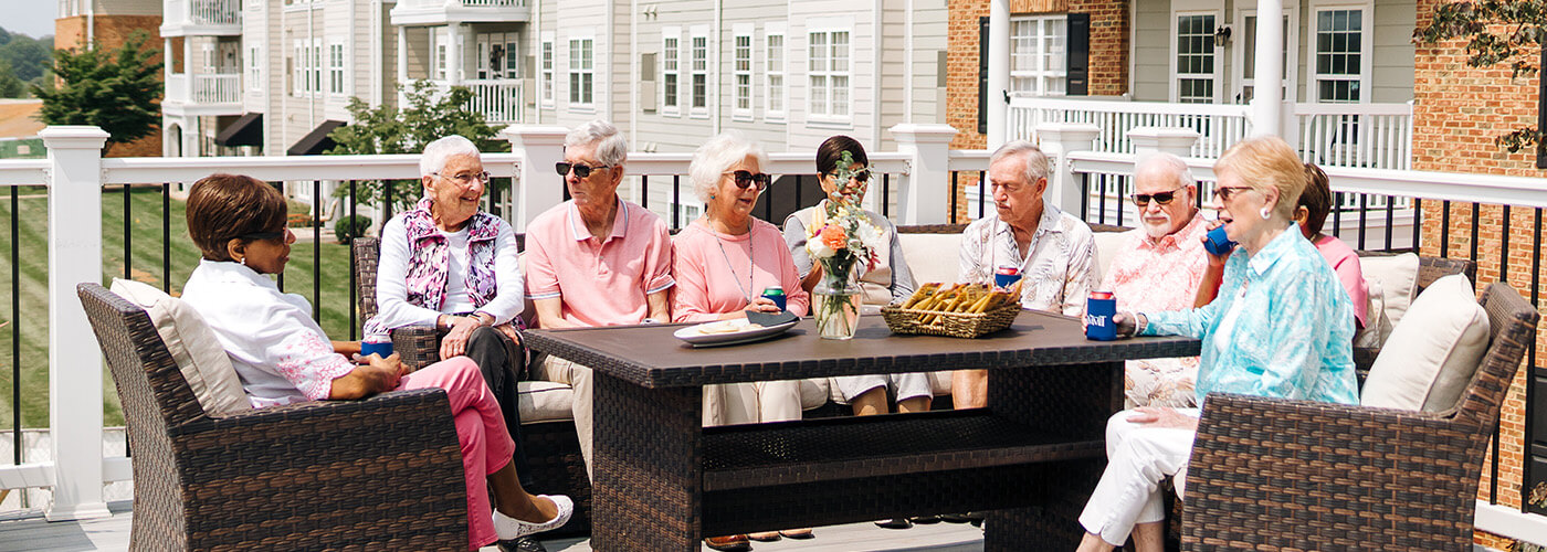 Group of seniors enjoying outdoor seating at a senior living community.