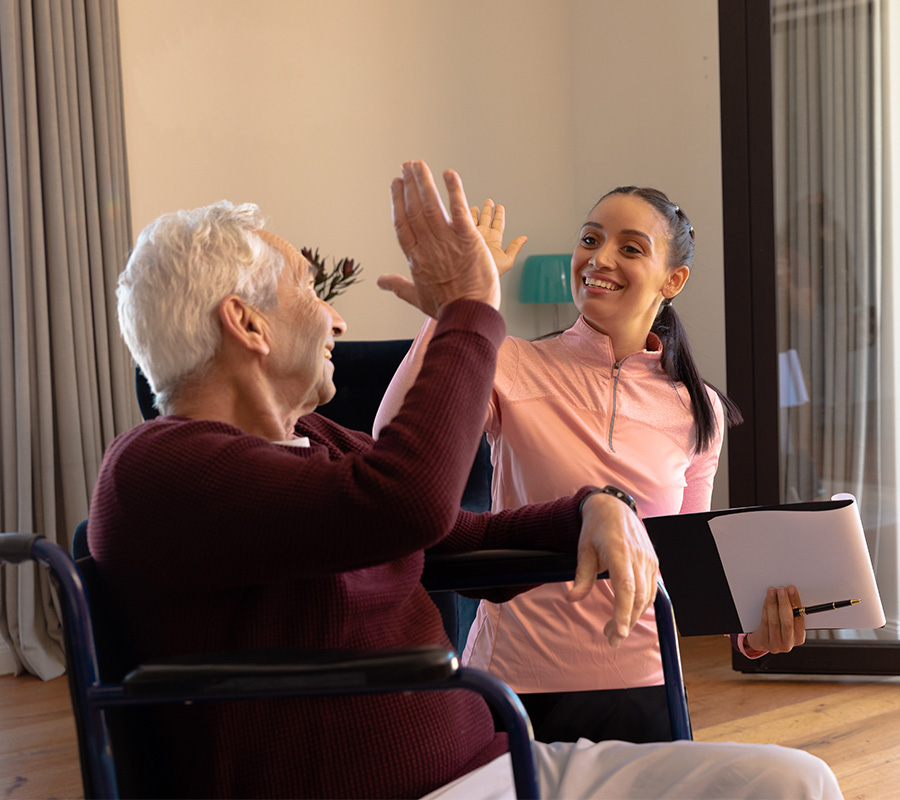 Senior man and physical therapist high five
