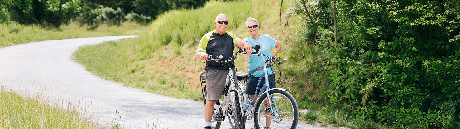 Senior couple riding bikes together on a path