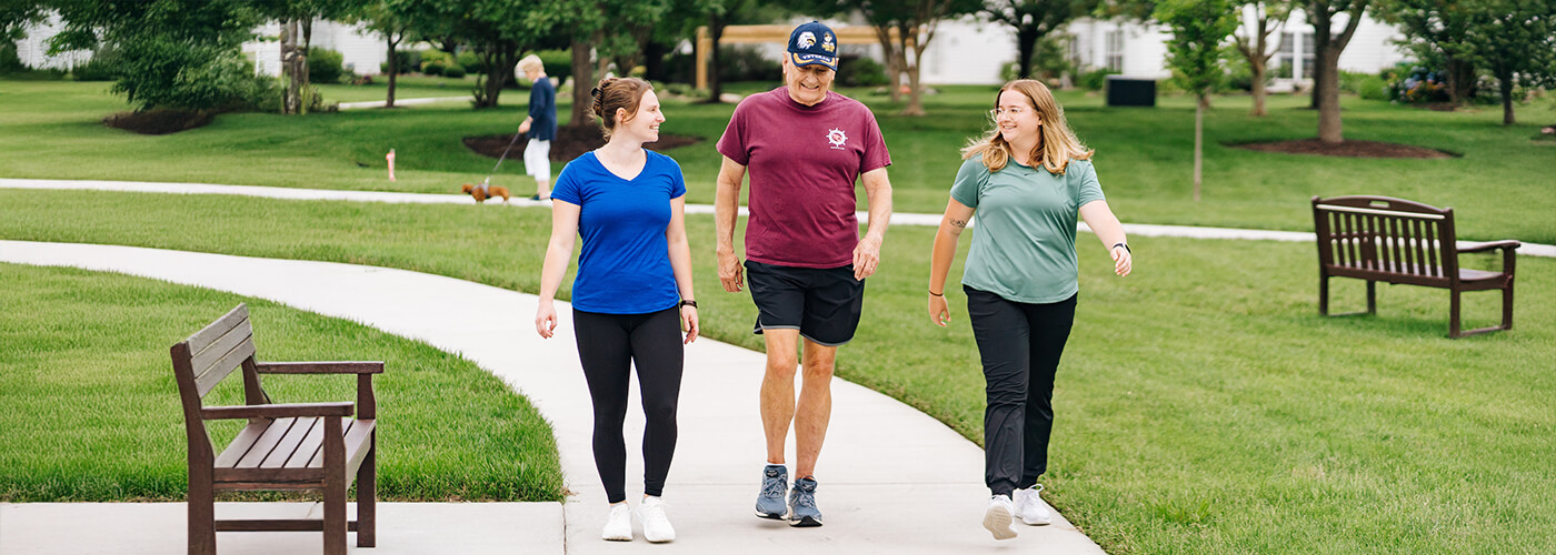 volunteers walking with senior man