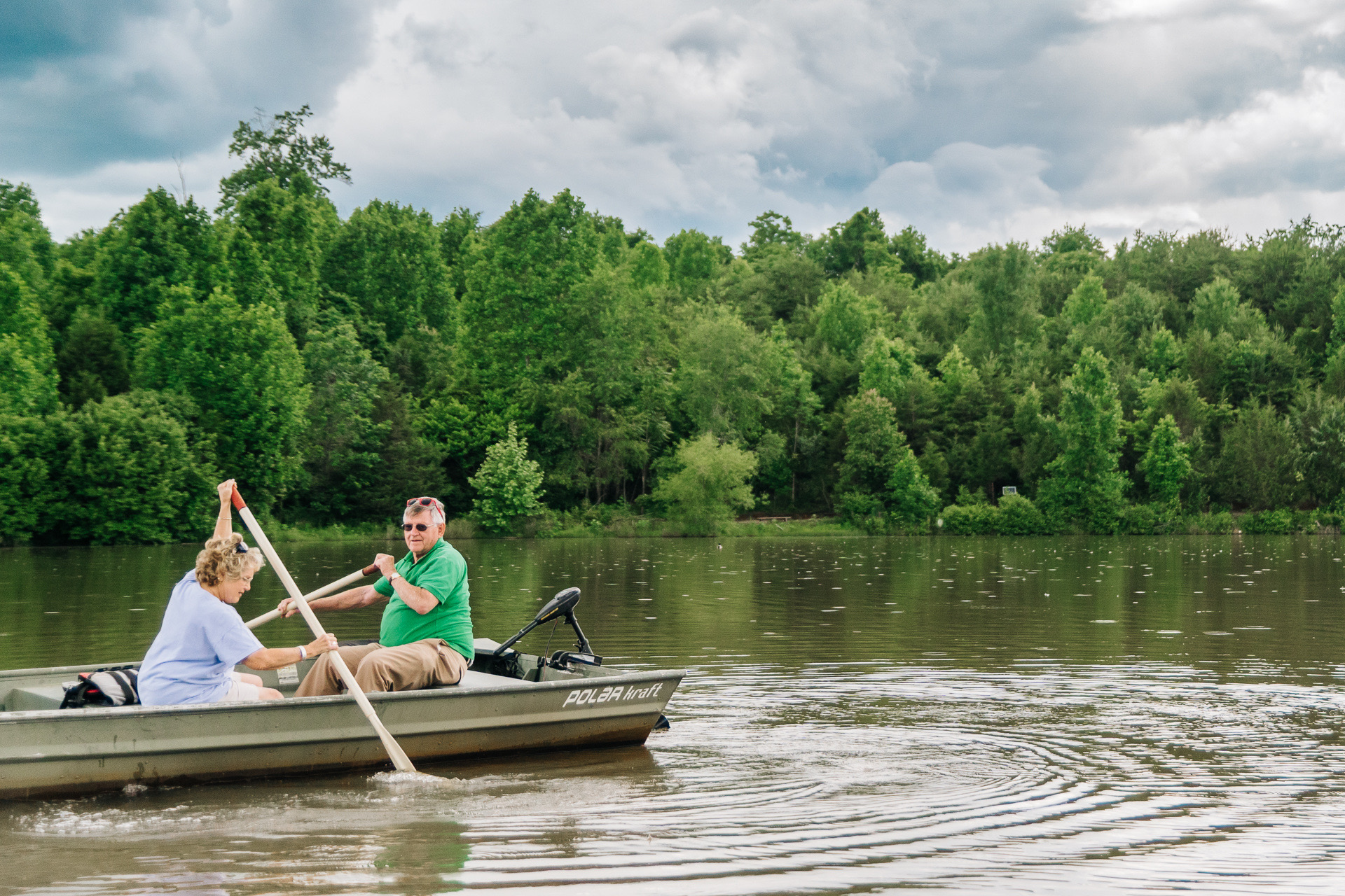 Senior couple paddling boat in water