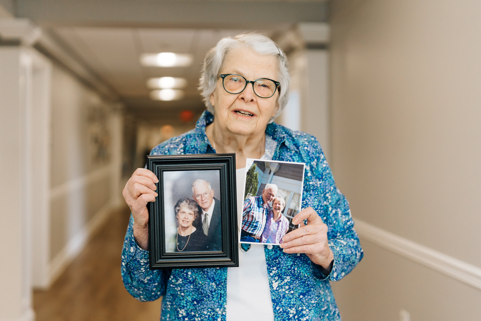 Liz Hodges holding up photos of her and her husband