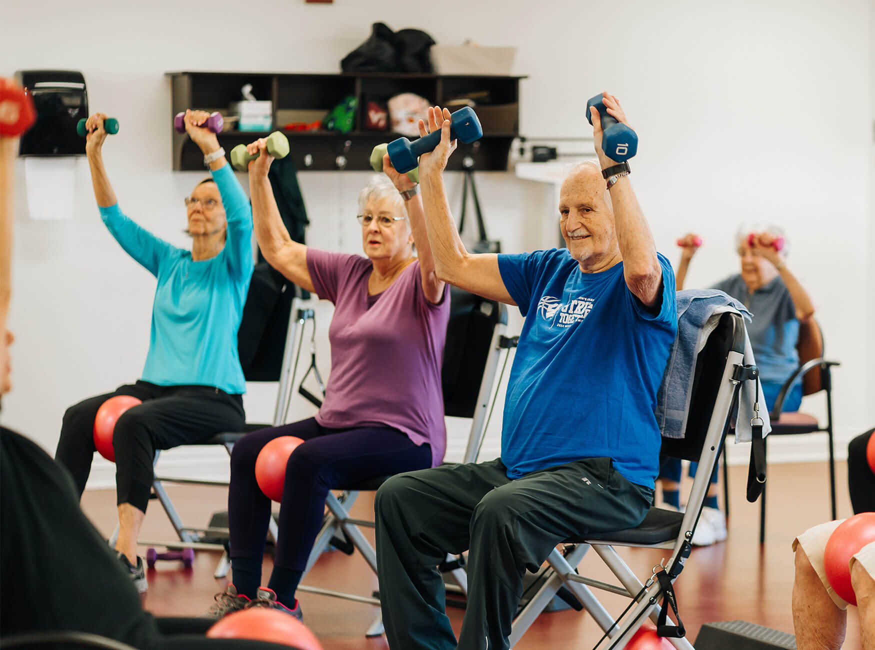 Seniors exercising with dumbbells in a community fitness class.
