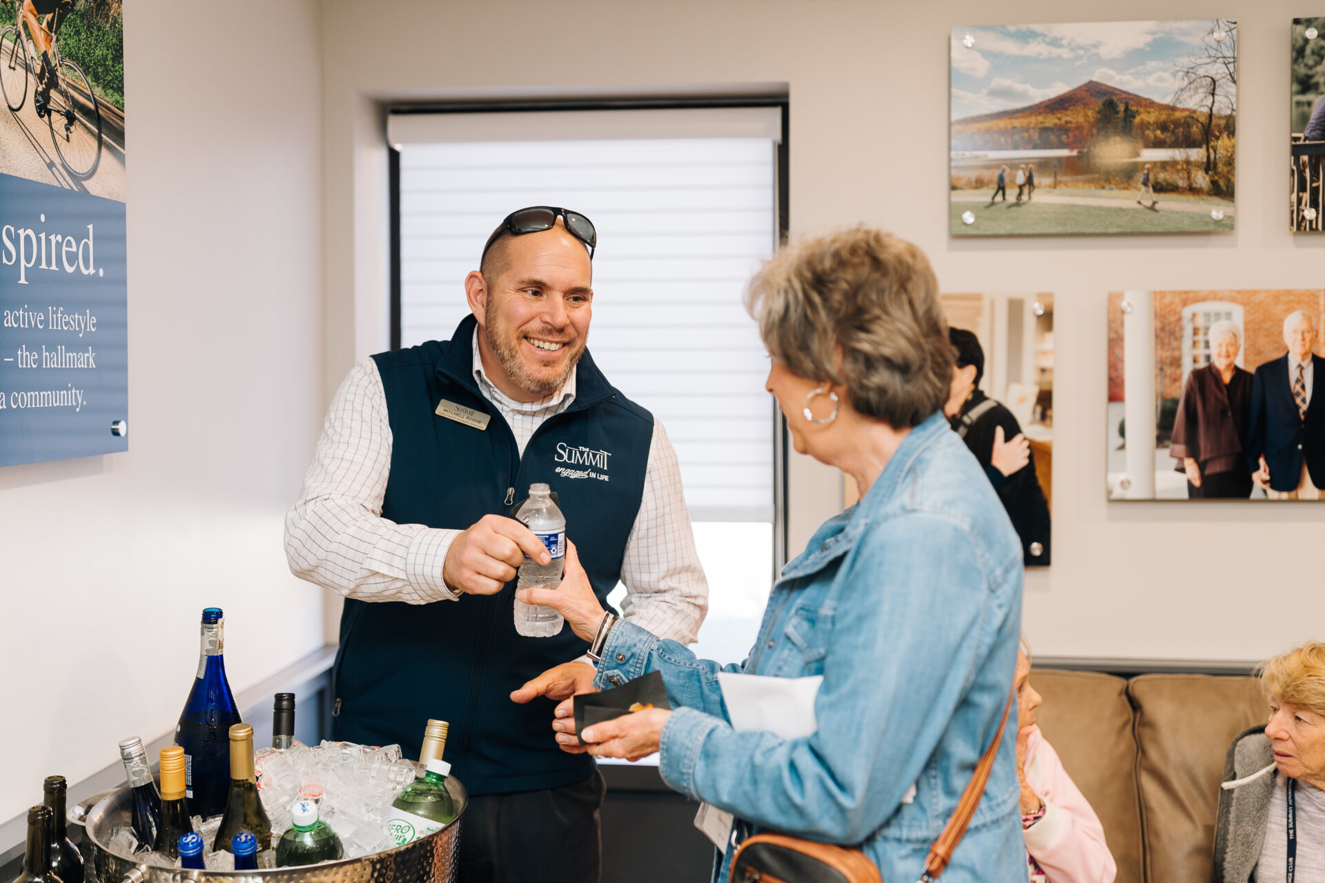 Staff handing a senior woman a water