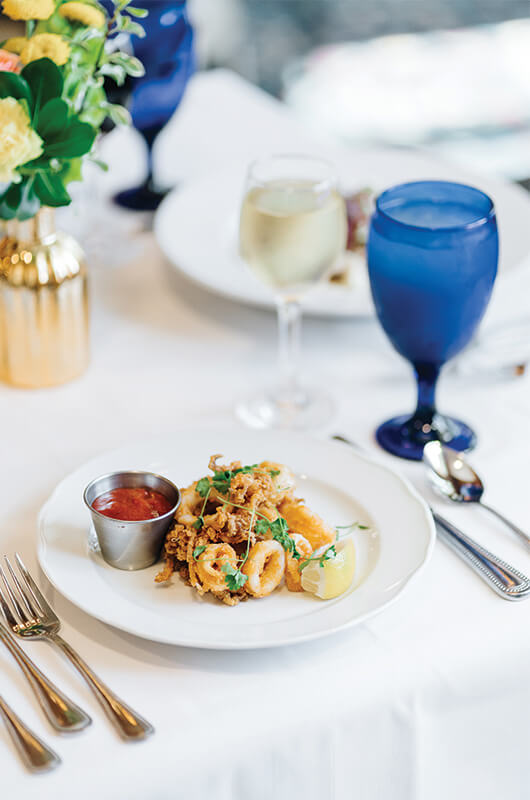 Elegant dining setup with fried calamari and white wine.