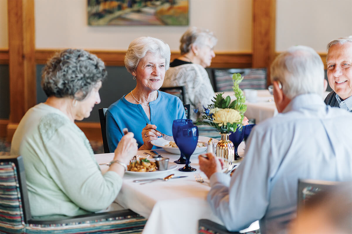Residents enjoying a meal together in a senior living community dining area.