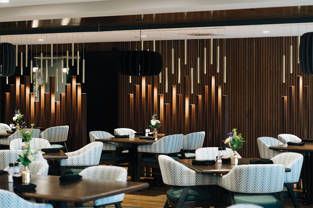 Elegant dining area with modern chairs and wood paneling in a community center.
