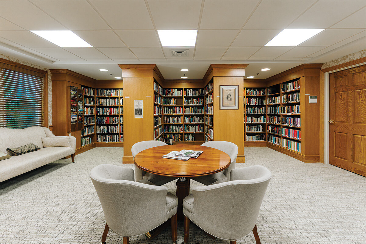 Library room with round table and chairs in a senior community.